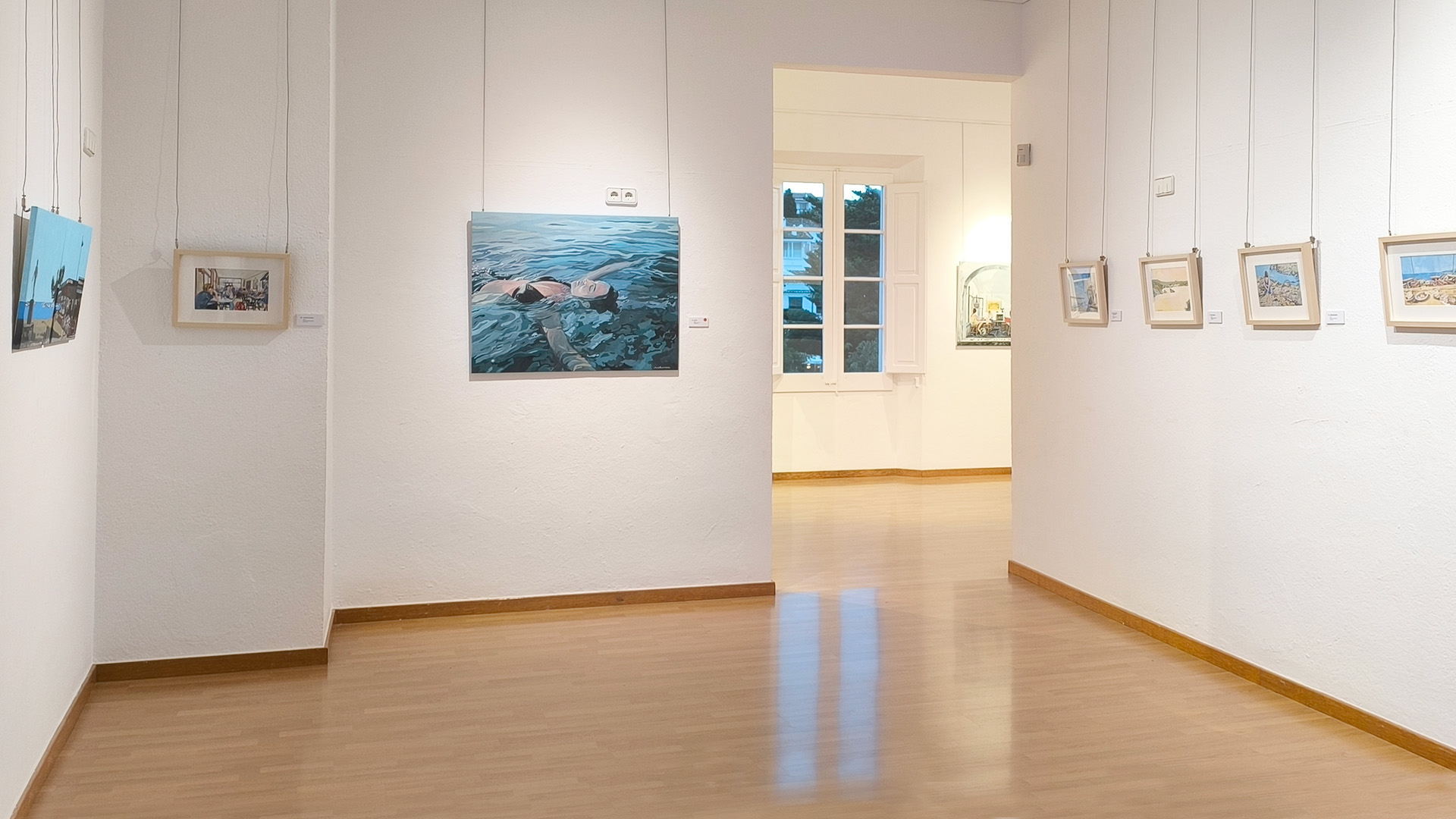 Vista de la sala mitjana de l’exposició MOMENTS, amb aquarel·les de petit format i obres en acrílic sobre tela de format més gran, marcant el pas cap a la sala següent del recorregut.